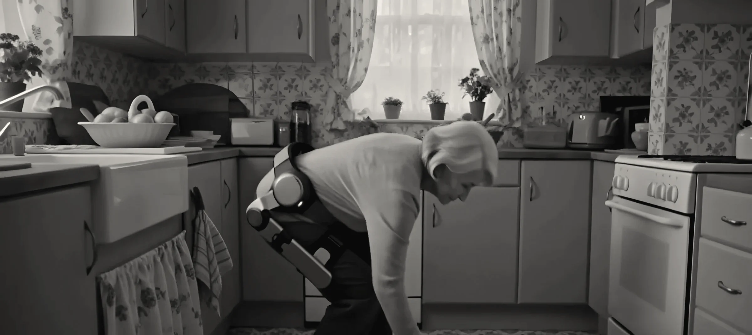 The woman bending at the knees in her kitchen to pick a wooden spoon up from the floor